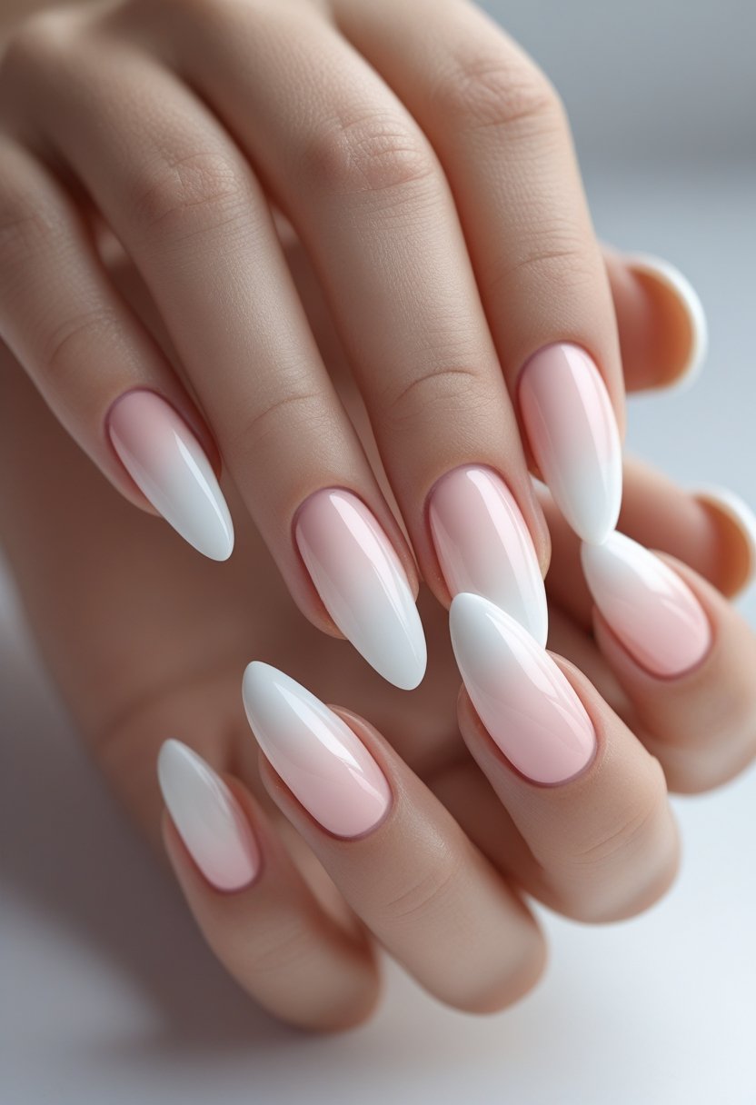 Close-up of hands with ombre French manicure nails blending soft blush pink and white tips.